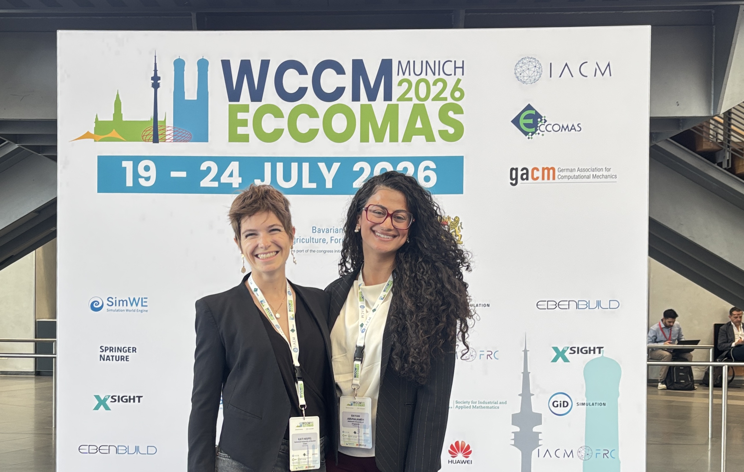 Bayan and Kati Nispel at the WCCM-ECCOMAS 2026 backdrop